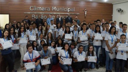 Foto de grupos de estudantes exibindo certificado e medalha na Câmara Municipal de Barão de Cocais