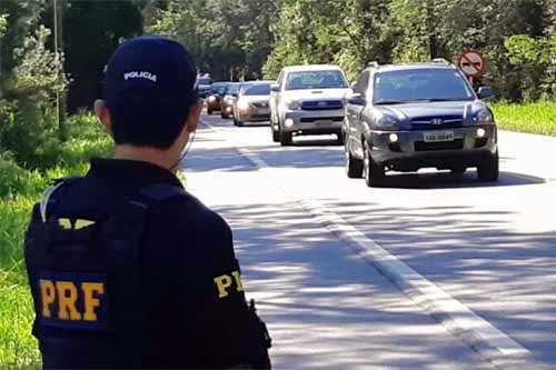 Foto de policial fiscalizando trânsito na estrada